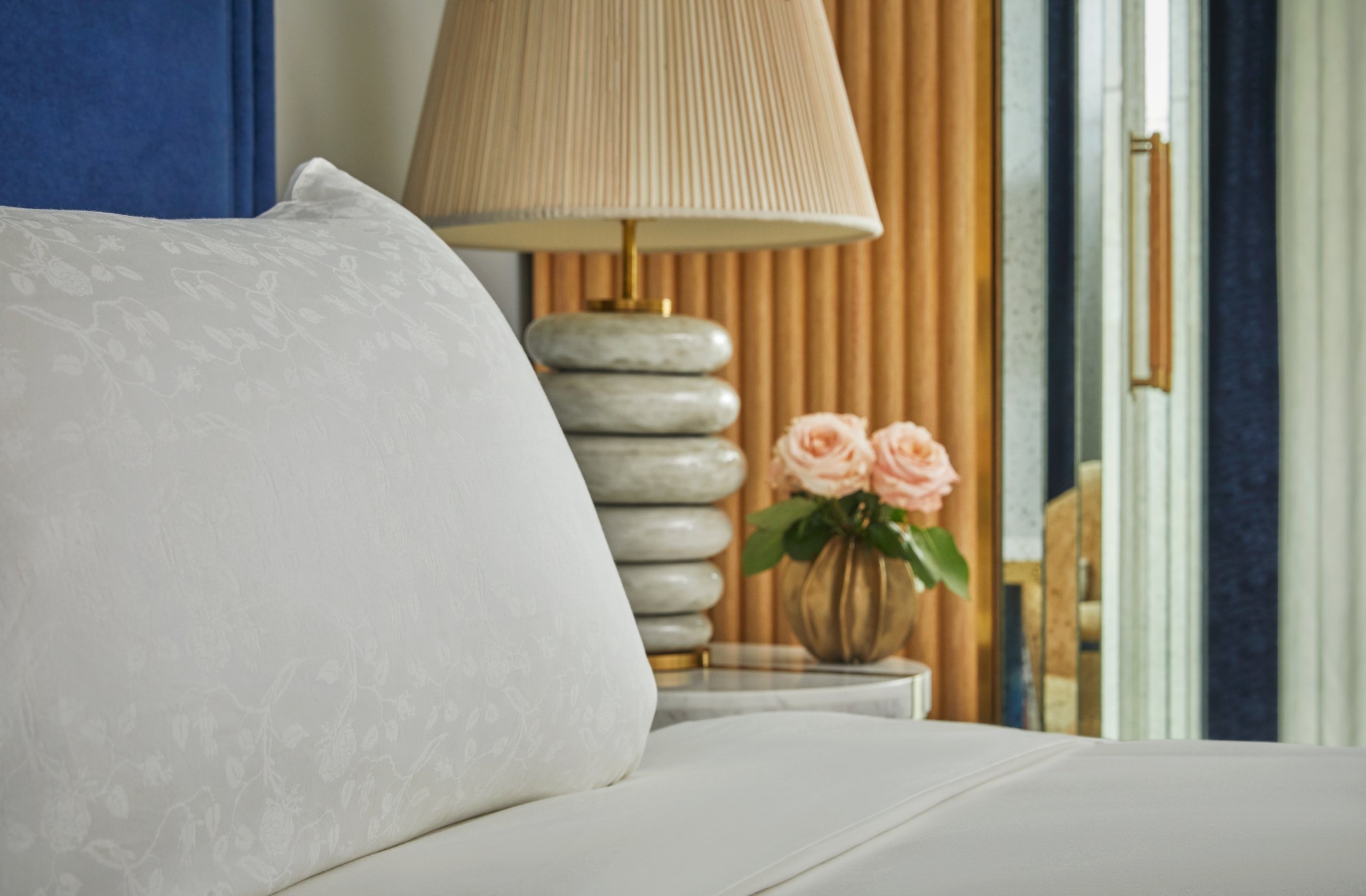 Close up of a bed and bed side table in a room at The Sun Rose