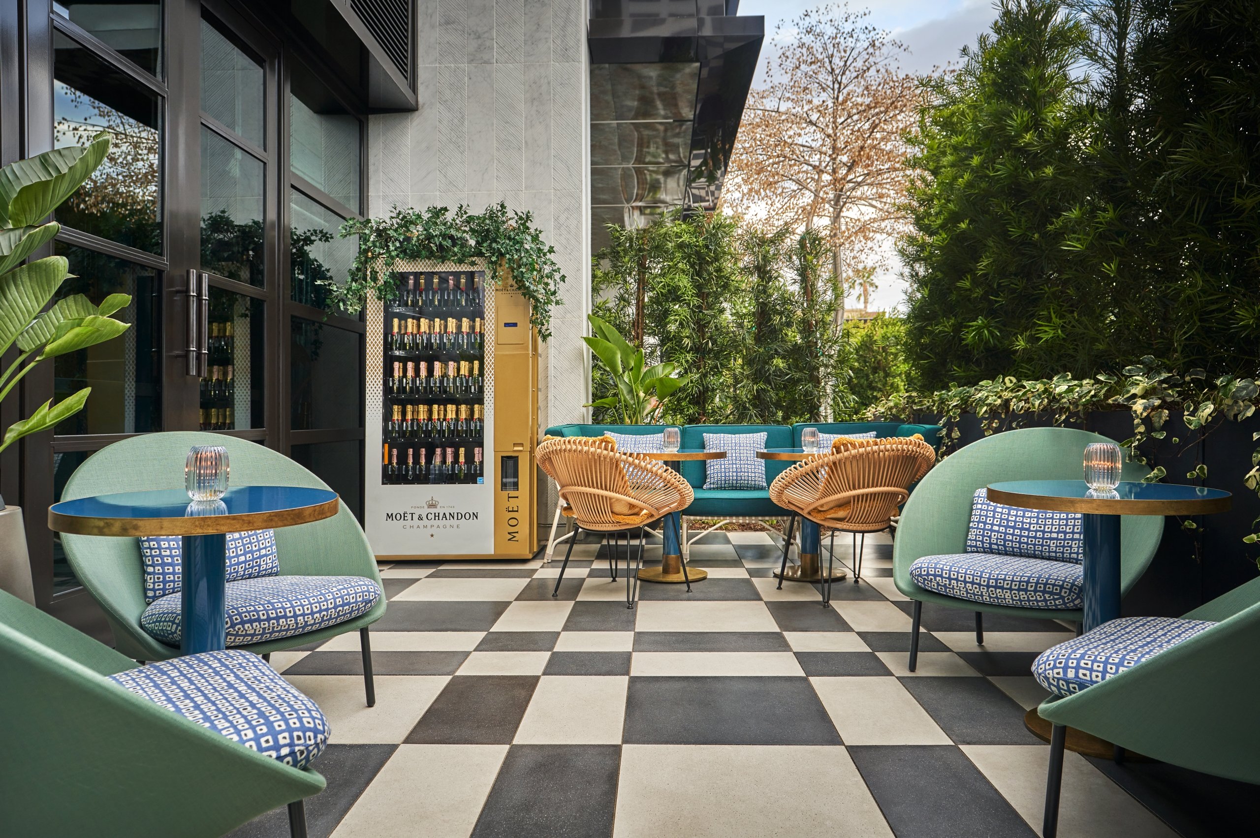 Outdoor seating area at The Sun Rose with a champagne vending machine in the background