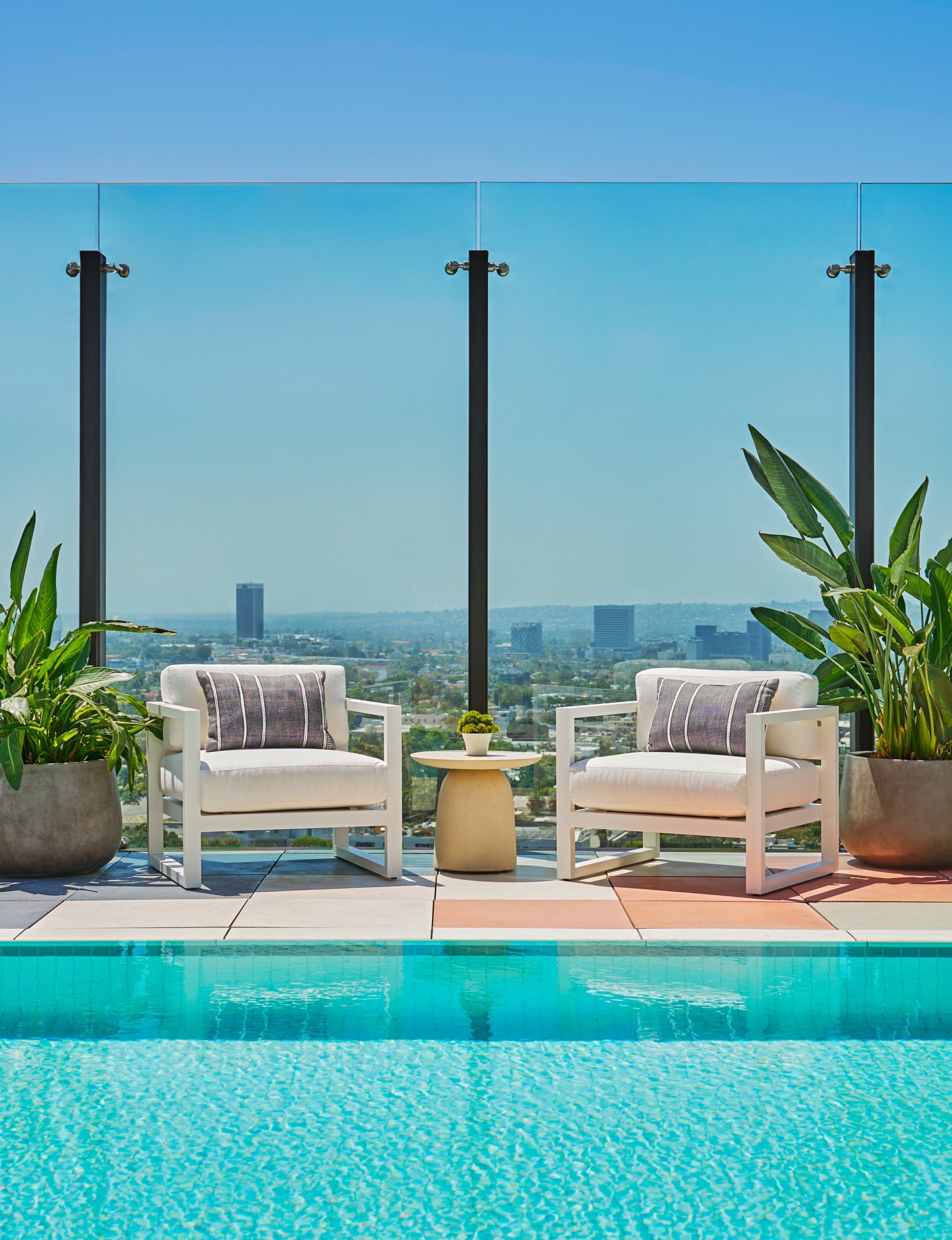 Two chairs in front of the pool at The Sun Rose with views of West Hollywood in the background