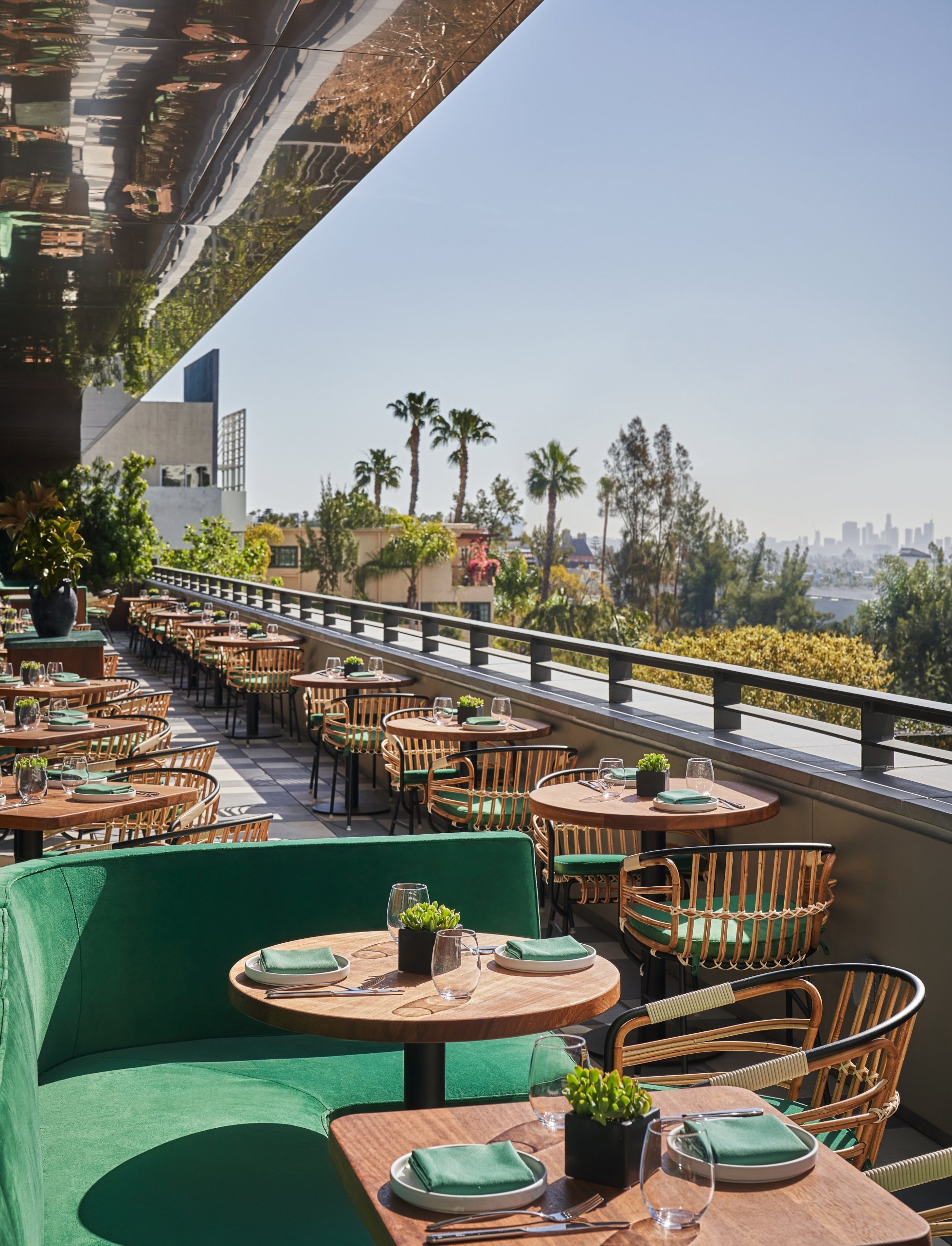 A dining area at The Sun Rose with tables and chairs lined up against the wall overlooking West Hollywood