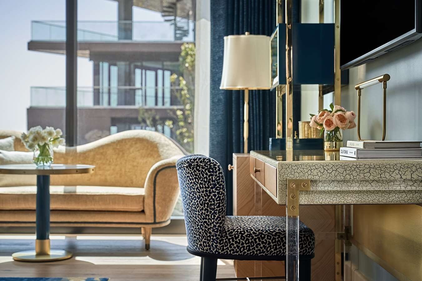 A desk in a room at The Sun Rose with a couch in the background