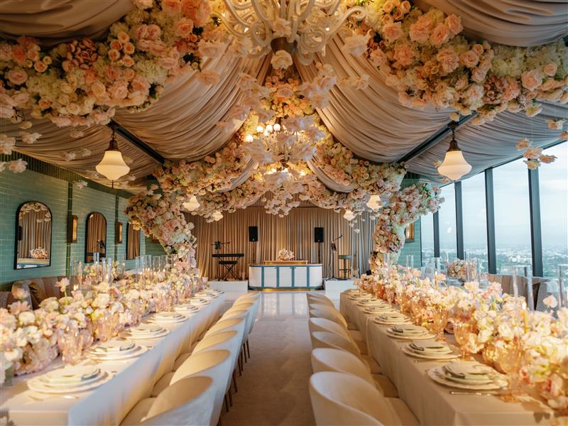 Merois Rooftop Restaurant decorated for a wedding reception, with long tables, candles, linen, florals, and warm lighting