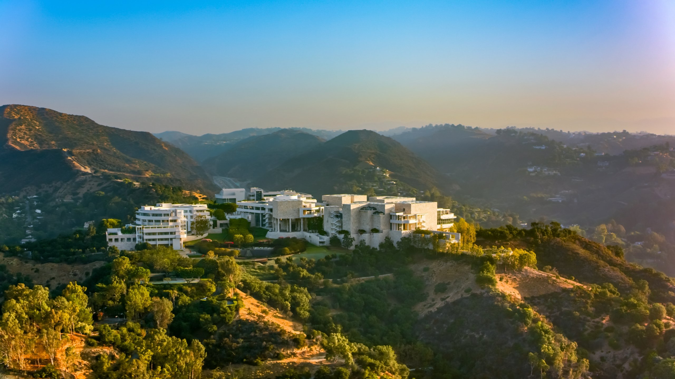The Getty Centre, surrounded by lush green hills and a setting sun.