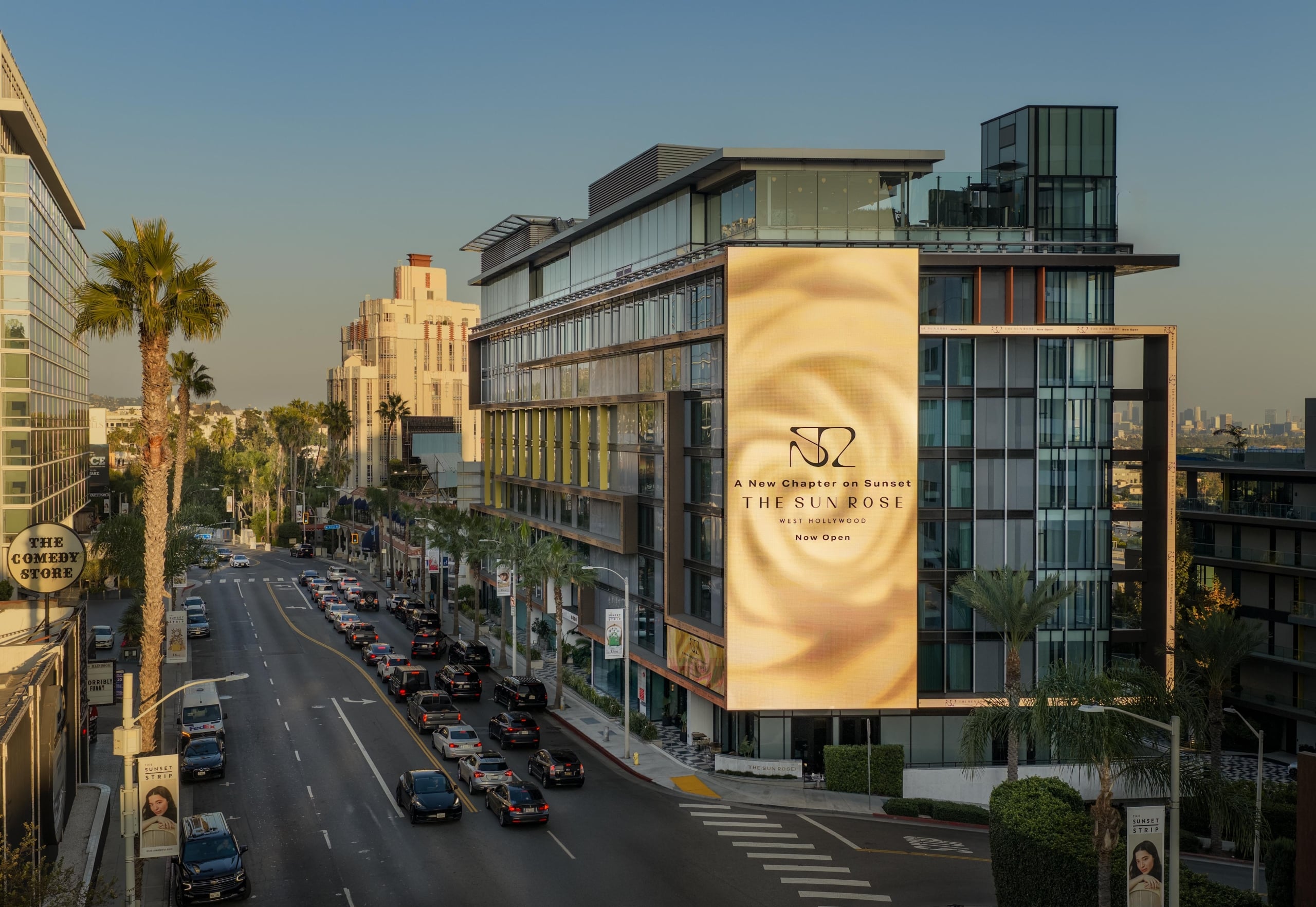 High-angle daytime view of The Sun Rose hotel on the Sunset Strip, featuring its iconic large rose digital billboard.