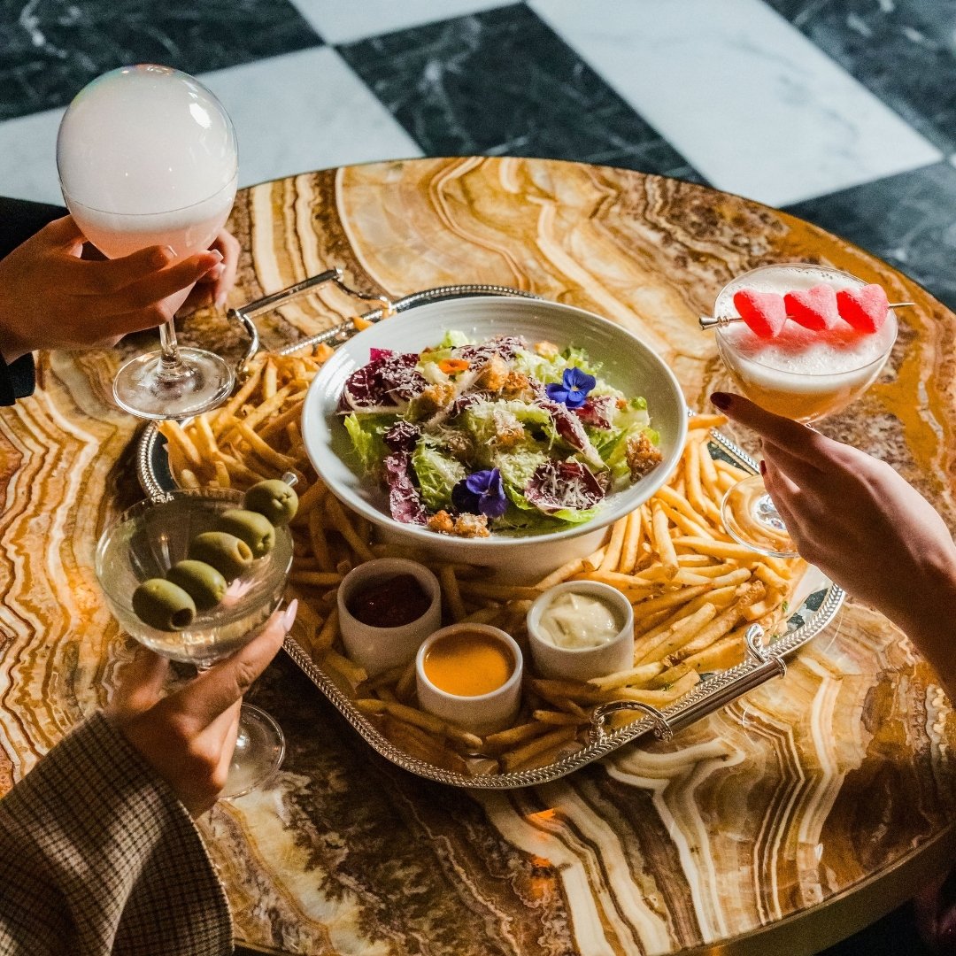 A sharable salad, fries, and three specialty martinis